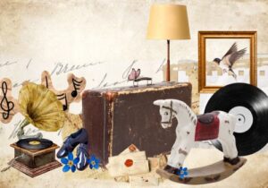 Ein Grammophon, ein Koffer, ein Schaukelpferd, eine Schallplatte und eine Stehlampe