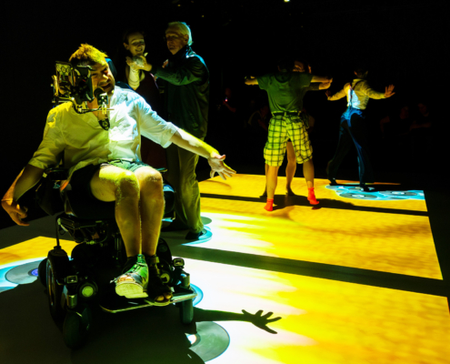 Eine Person im Rollstuhl tanzt auf einer Bühne.