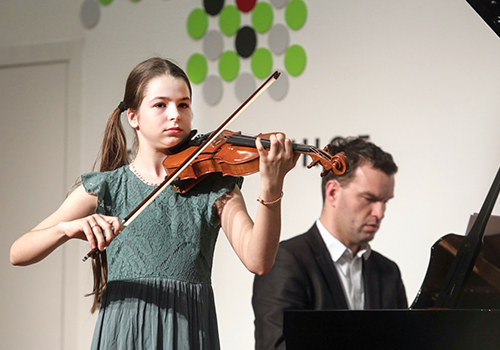 ca. 10 jähriges Mädchen mit Violine und Mann am Klavier