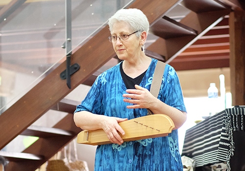 Frau mit Musikinstrument in der Hand